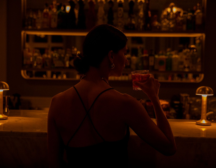 Woman sitting at N/5 – THE BAR enjoying a cocktail.