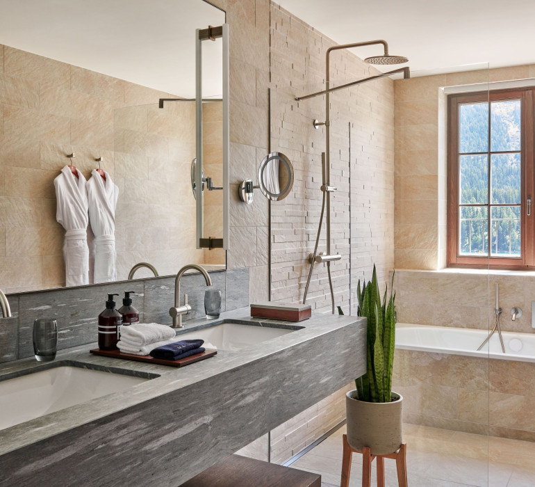 Modern bathroom with an open shower, bath tub and a stone sink