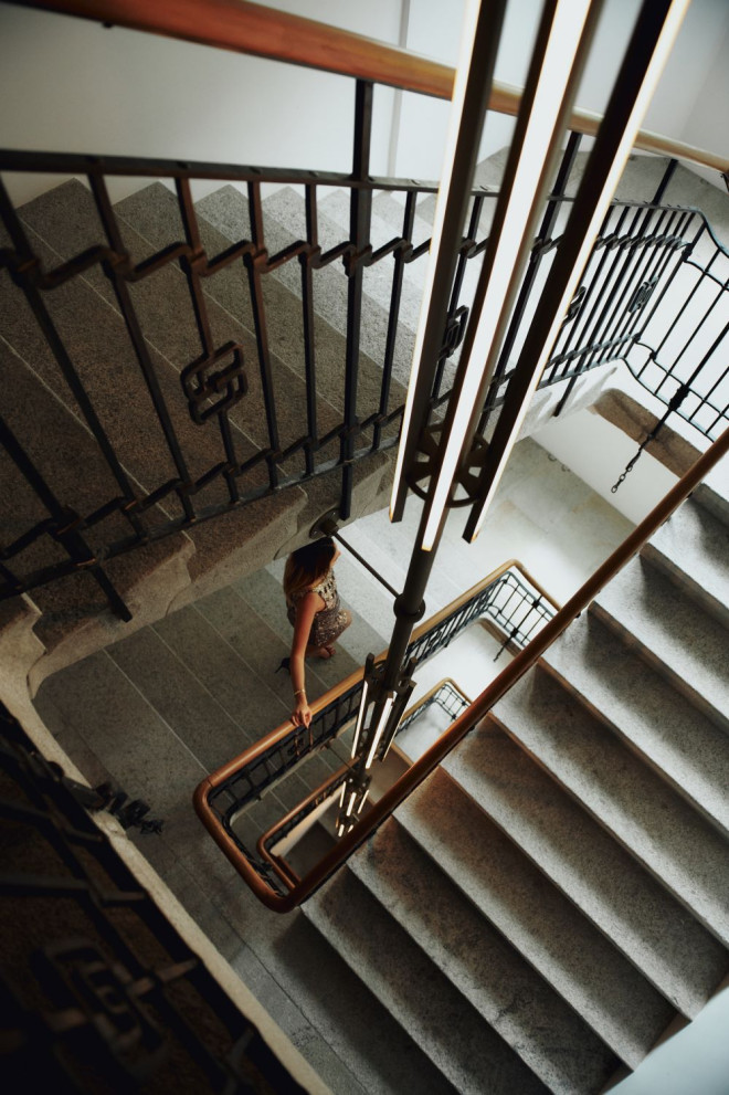 Staircase in a high building with a woman walking down