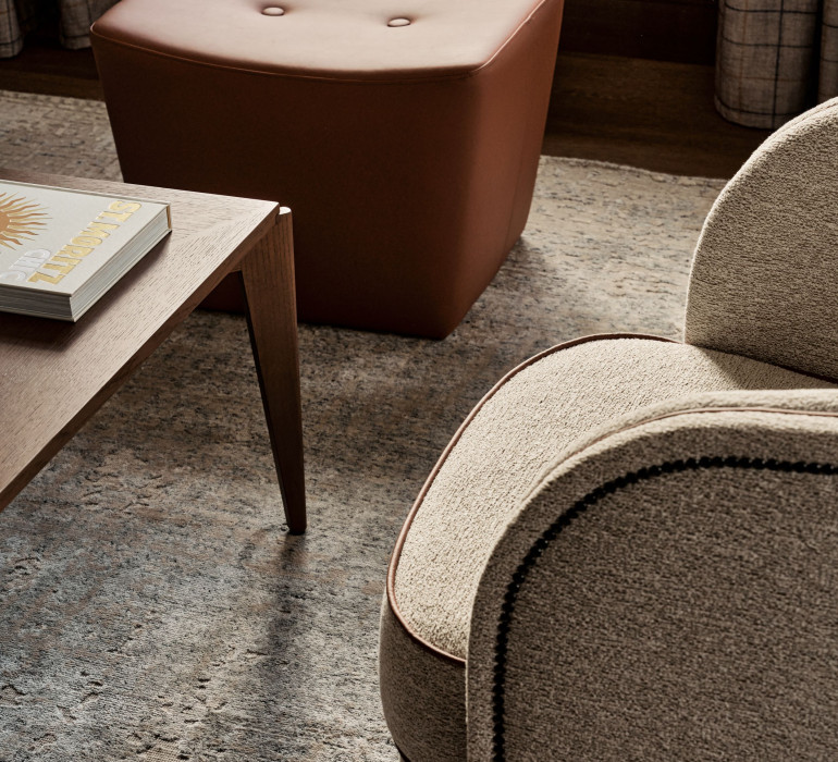 Details of luxury arm chairs and a wooden coffee table in natural colors