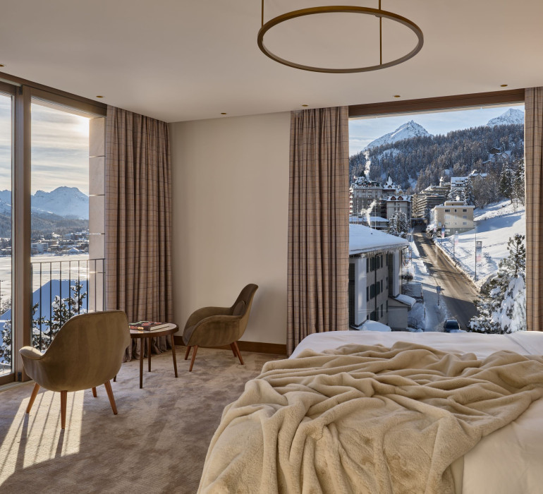 Hotel room with a double bed infront of the terrace full of snow