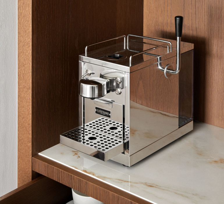 Silver coffee machine on a marble plate in a brown cupboard