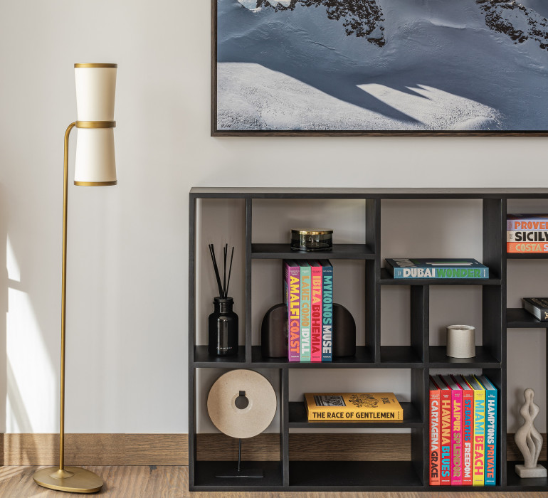 Elegant hotel suite with a living room, a shelf, a light and a picture