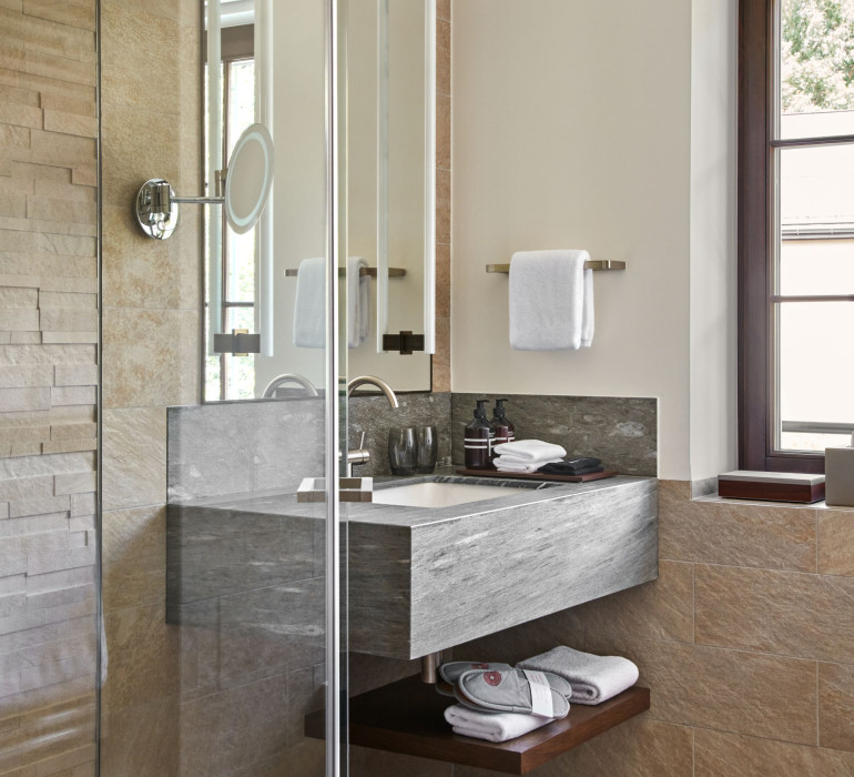 Modern bath room with a grey sink, stone tiles and much day light