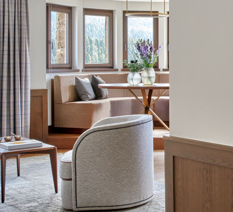 Hotel suite with a living room, a corner bench and a view at the lake in St. Moritz