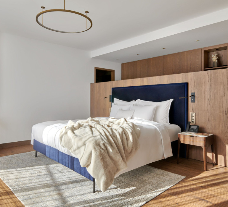 King size bed with a blue frame infront of a wooden wall