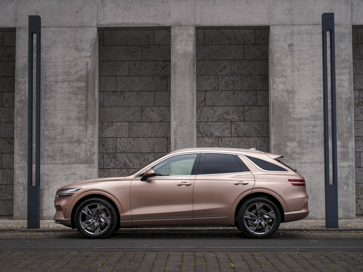 A rose golden car is parked in front of a grey wall at the luxury hotel st moritz