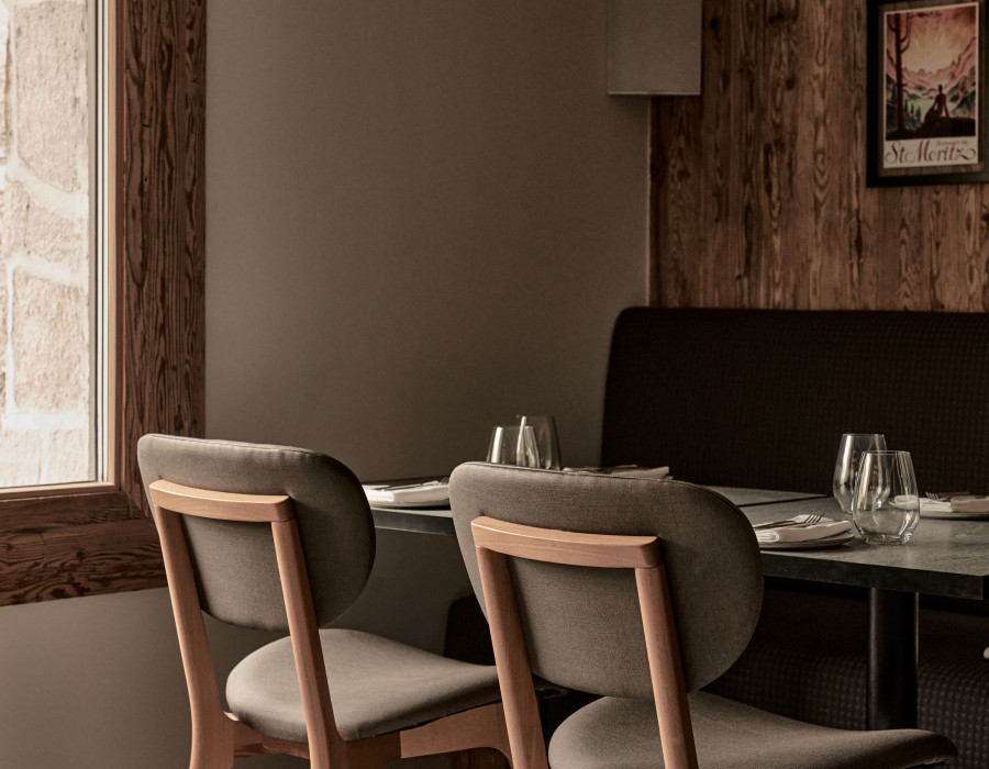 Corner table with two beige chairs underneath a window