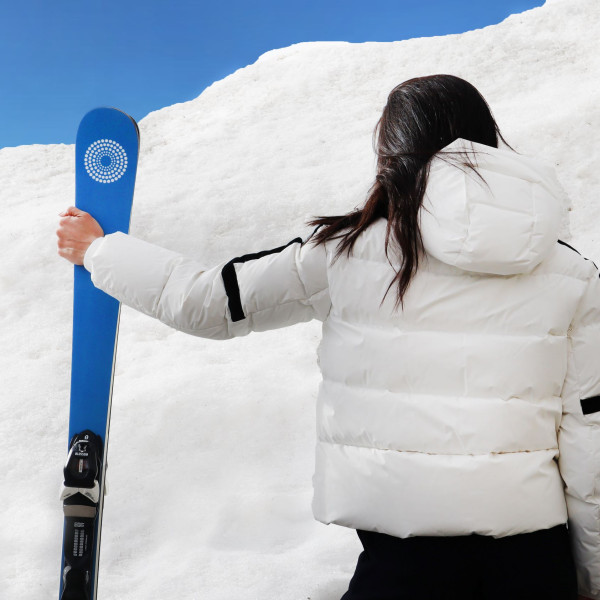 Donna con gli sci in mano, pronta per la sua vacanza sulla neve