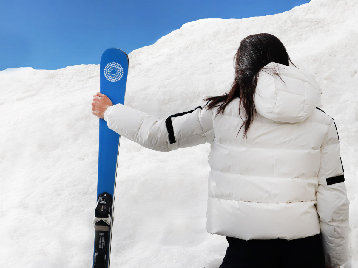 Frau hält Skier in den Händen, bereit für den Skiurlaub